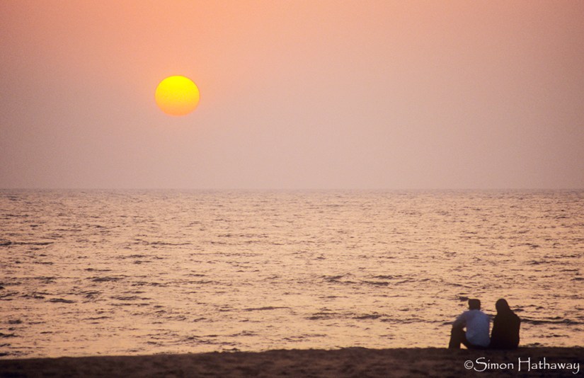 A couple enjoy the sunset off the Keralan coast, India.. Image shot 01/2007. Exact date unknown.